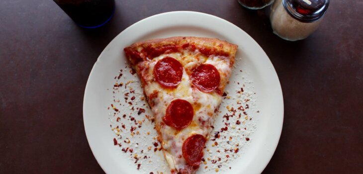 sliced pepperoni pizza on white ceramic plate